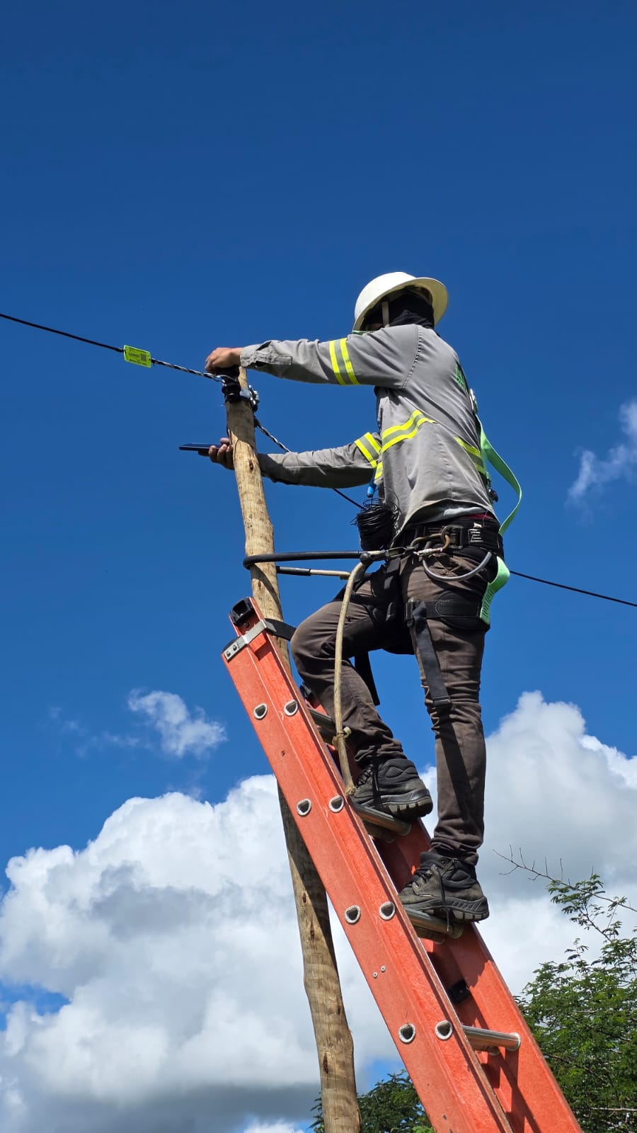 Técnico trabalhando com fibra óptica no poste